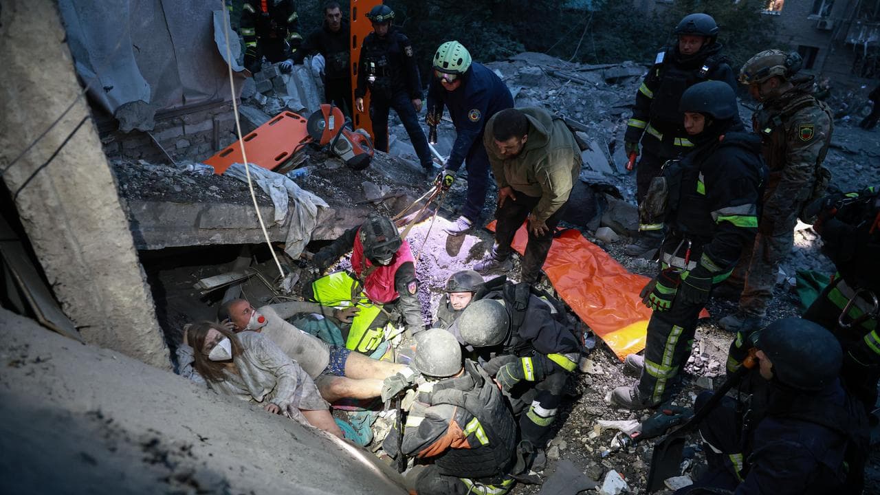 Rescue workers pull a family from the rubble