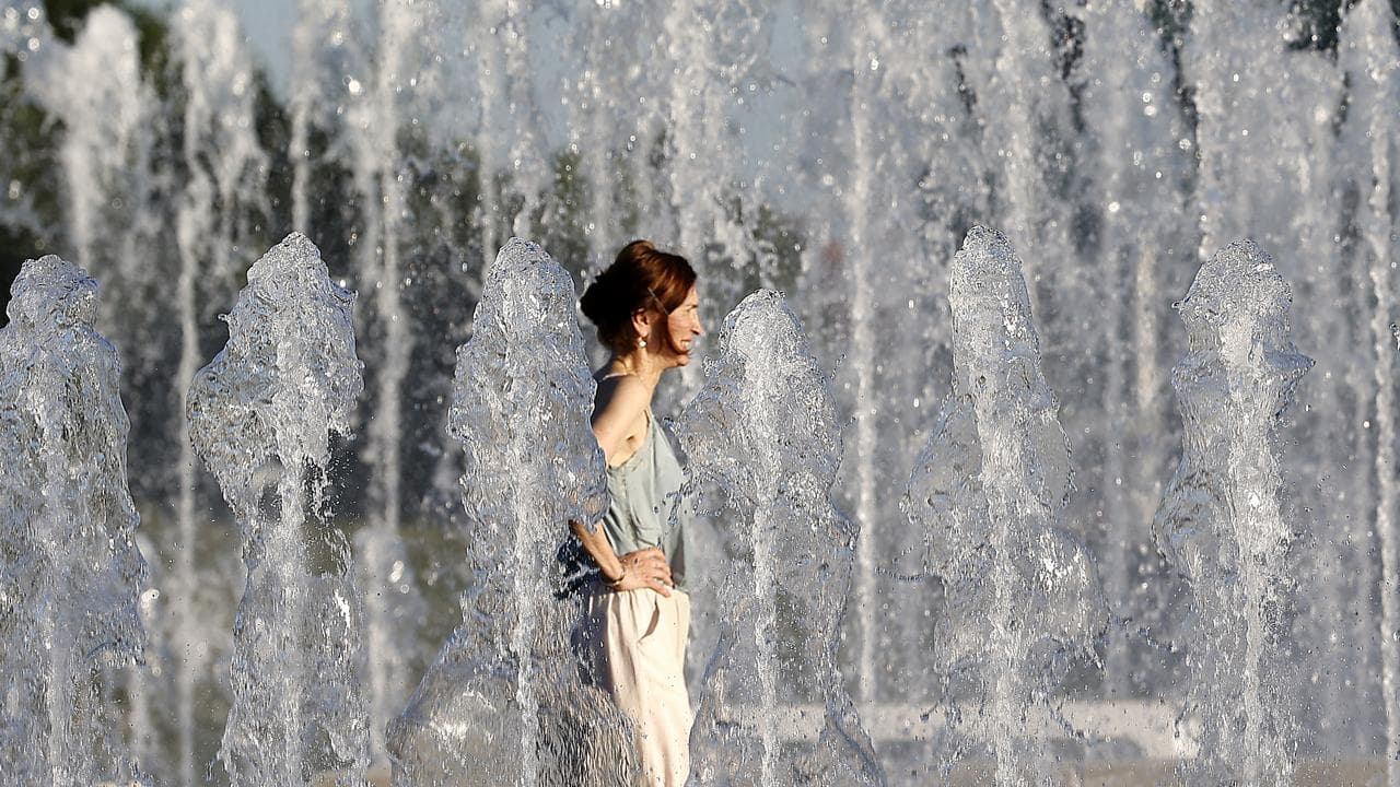 A woman cools off at a fountain in downtown Zagreb, Croatia