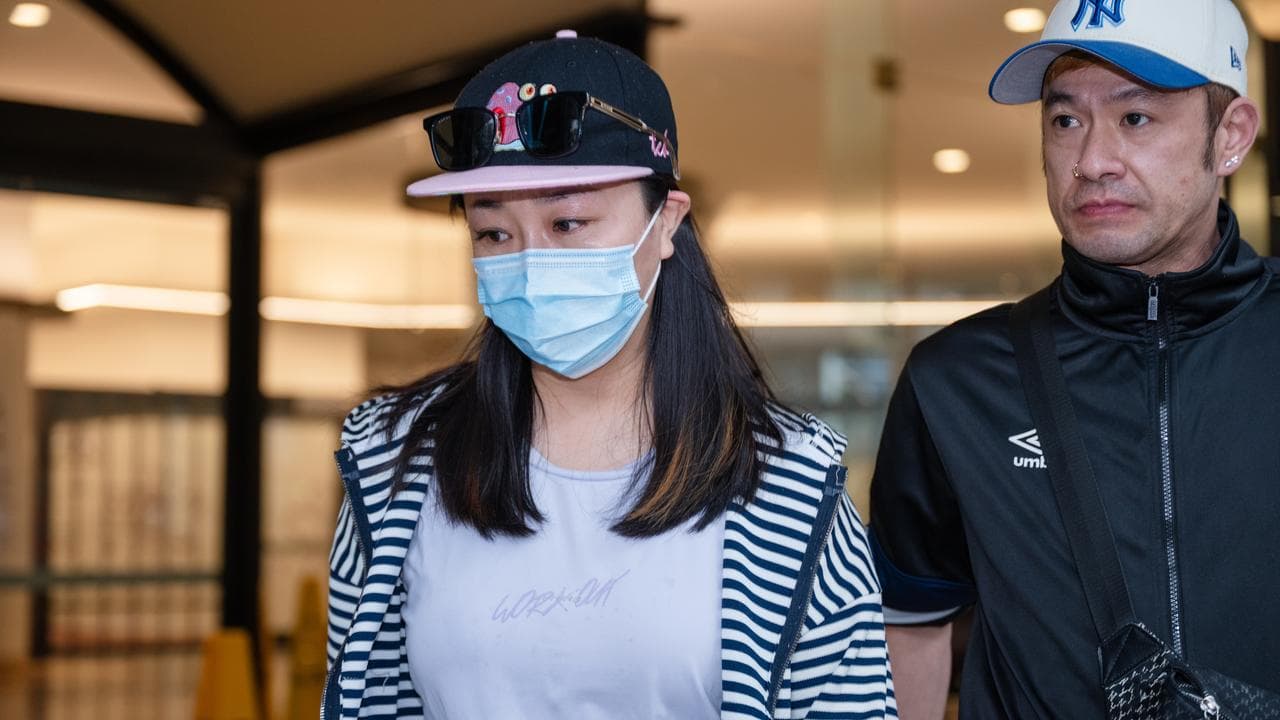 woman in face mask leaves court
