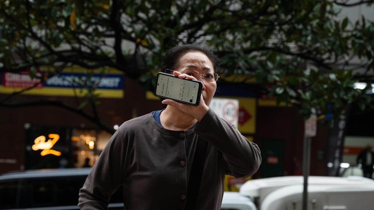 woman shields face with phone