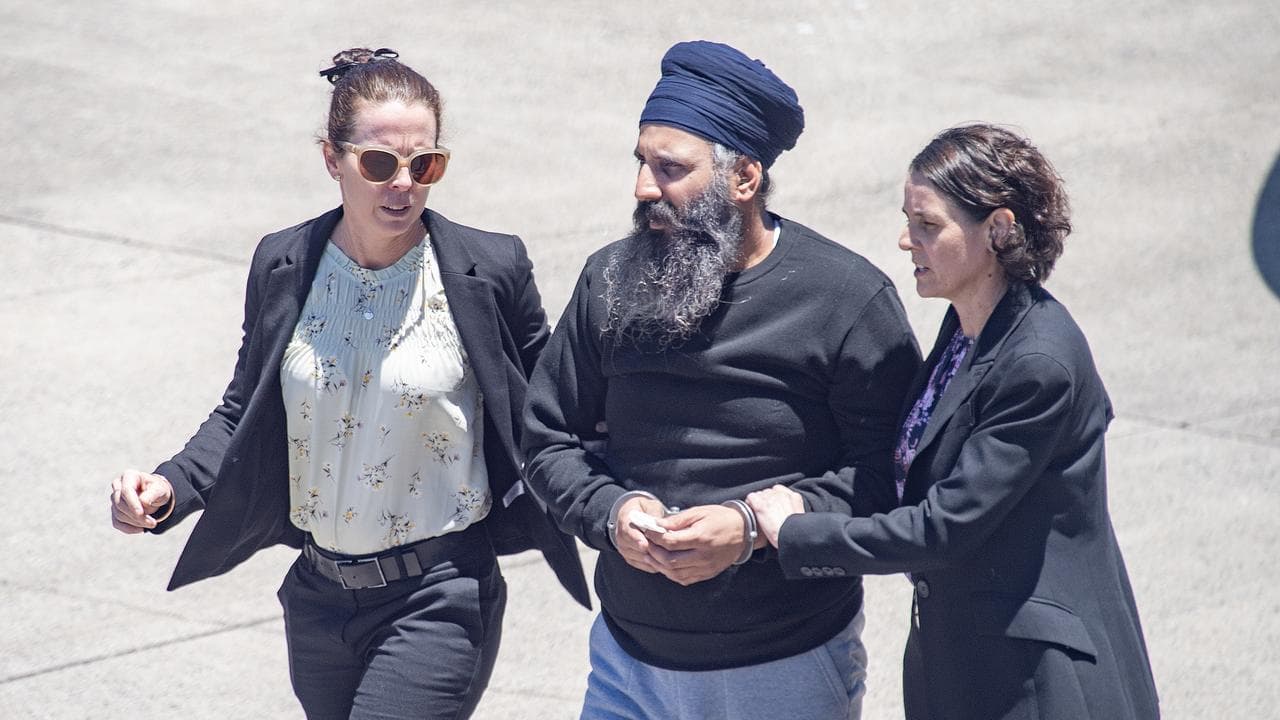 man in turban and long beard in handcuffs