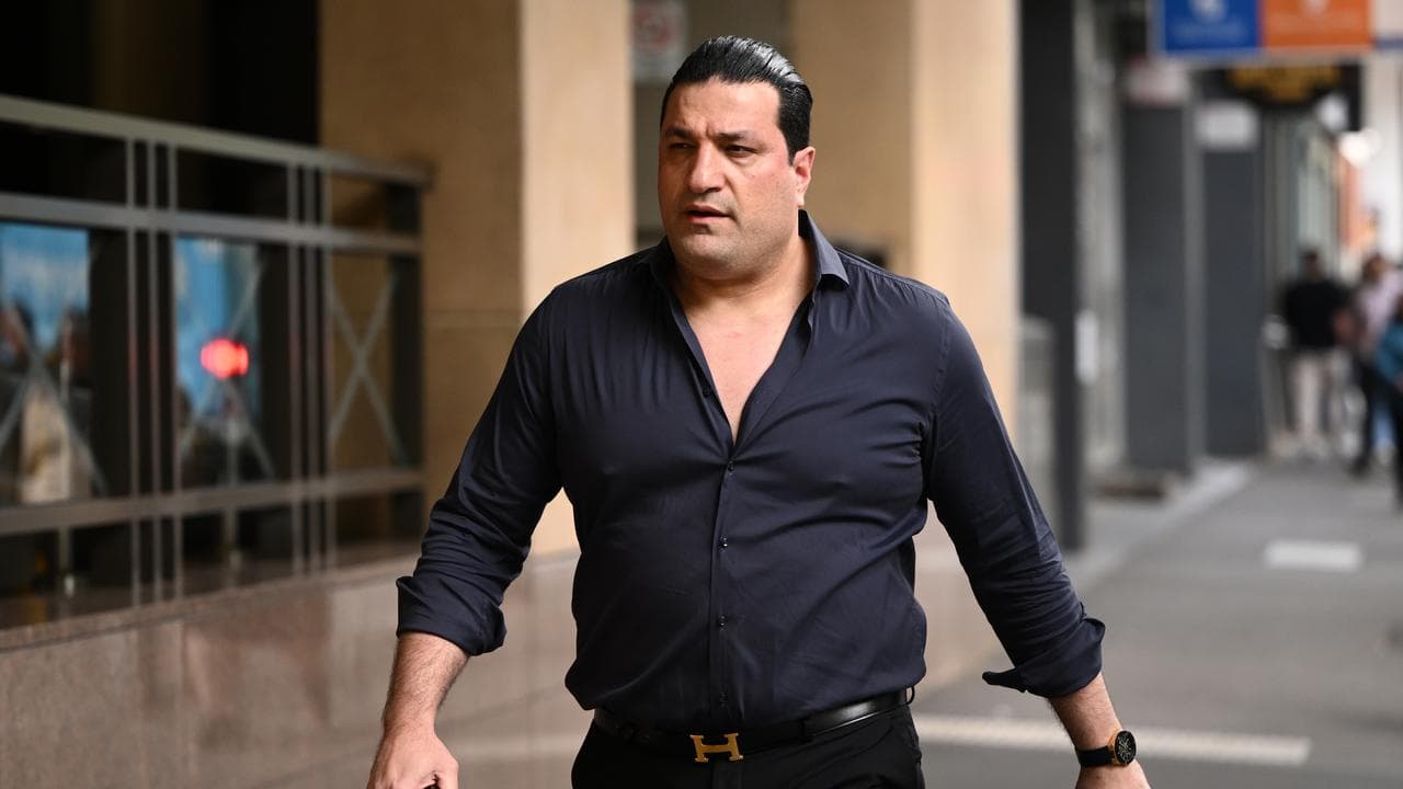 man in purple shirt walks to court