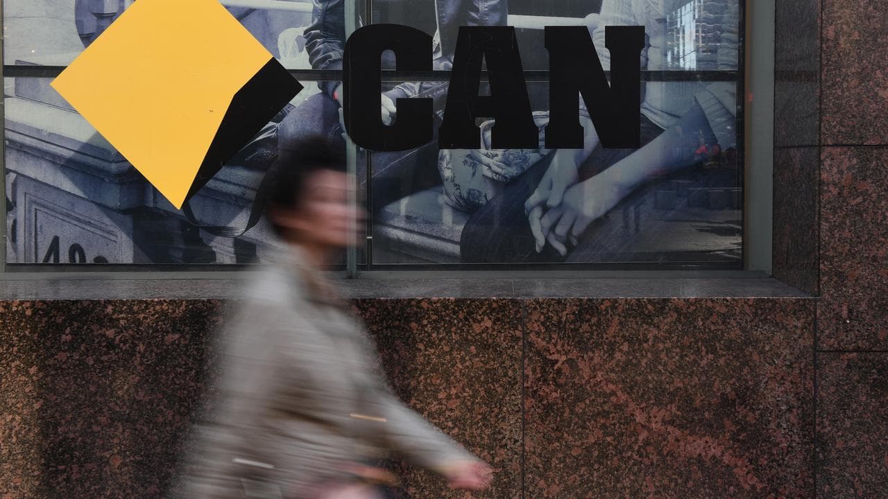 Workers walk past a Commonwealth Bank of Australia branch