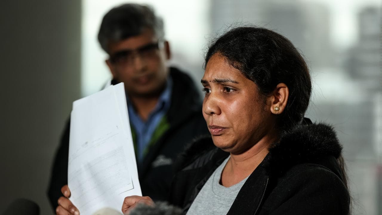 woman holds paper up to media cameras