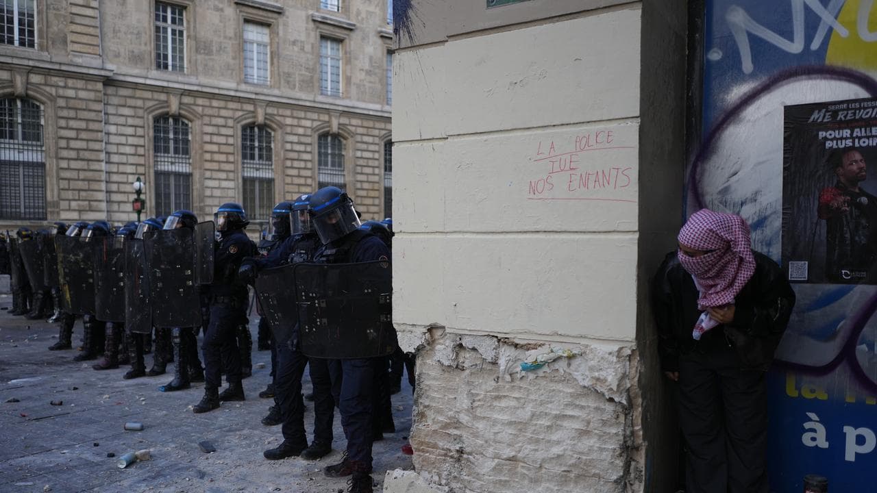 A protester watches riot police