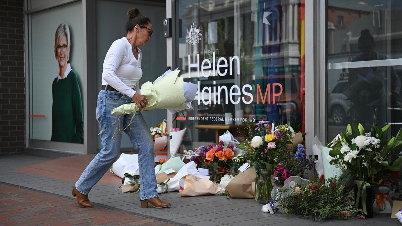 A person arrives with flowers at the office of Helen Haines