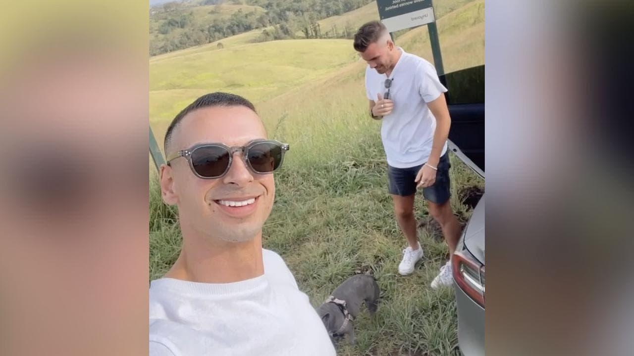 two men and a dog in a field