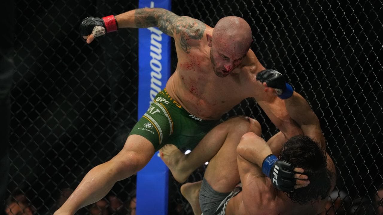 Alexander Volkanovski, left, pins down Russia's Movsar Evloev