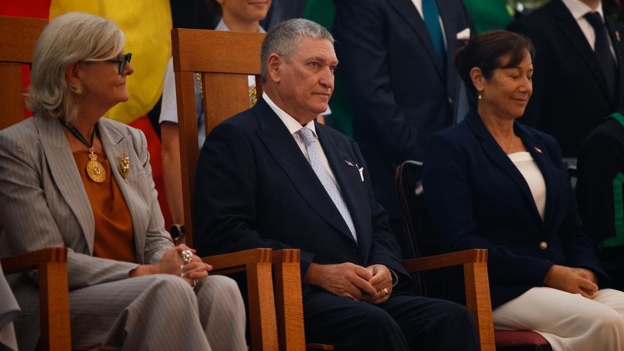man seated between two women
