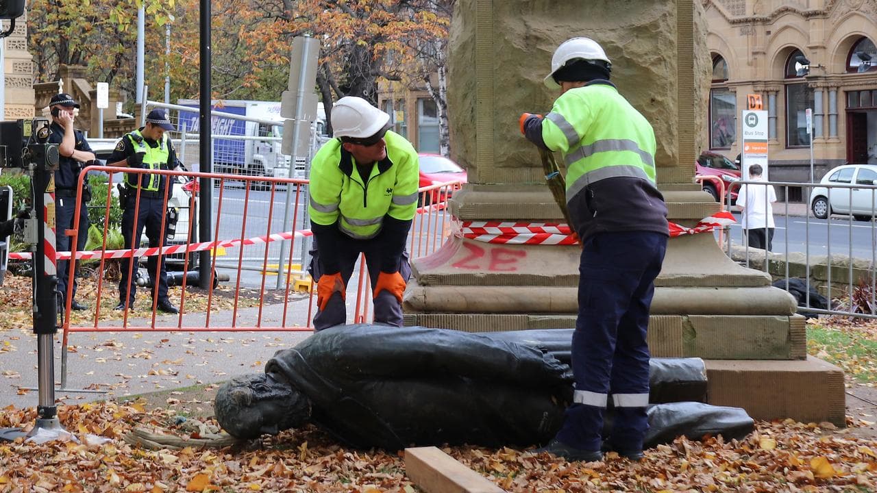 Council workers remove the statue