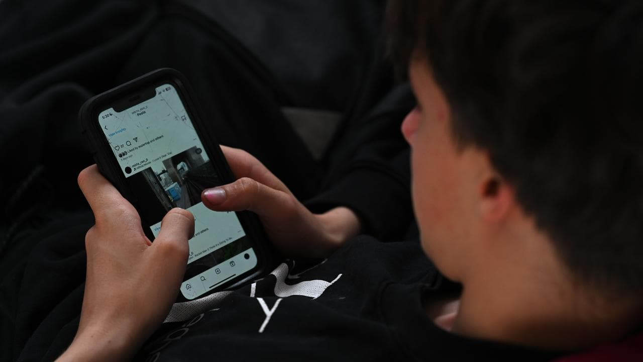 A teenager uses his mobile phone to access social media (file image)