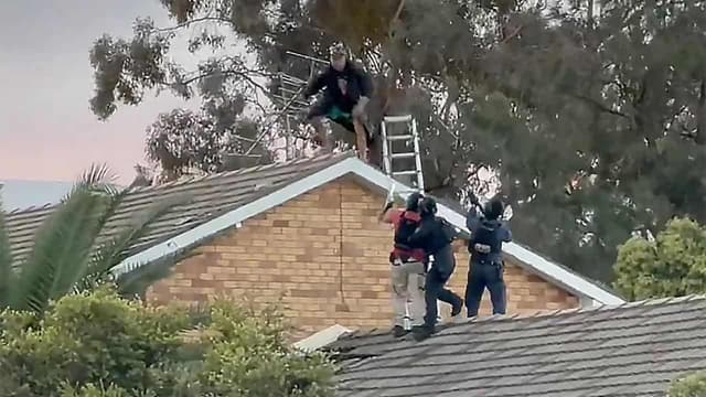 Man charged with murder after rooftop stand-off