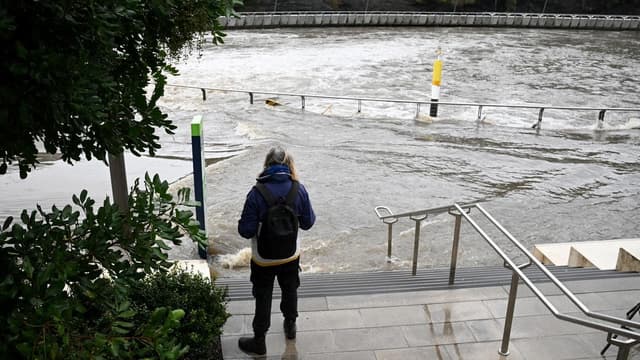 Father and son dead in river as flood threat grows