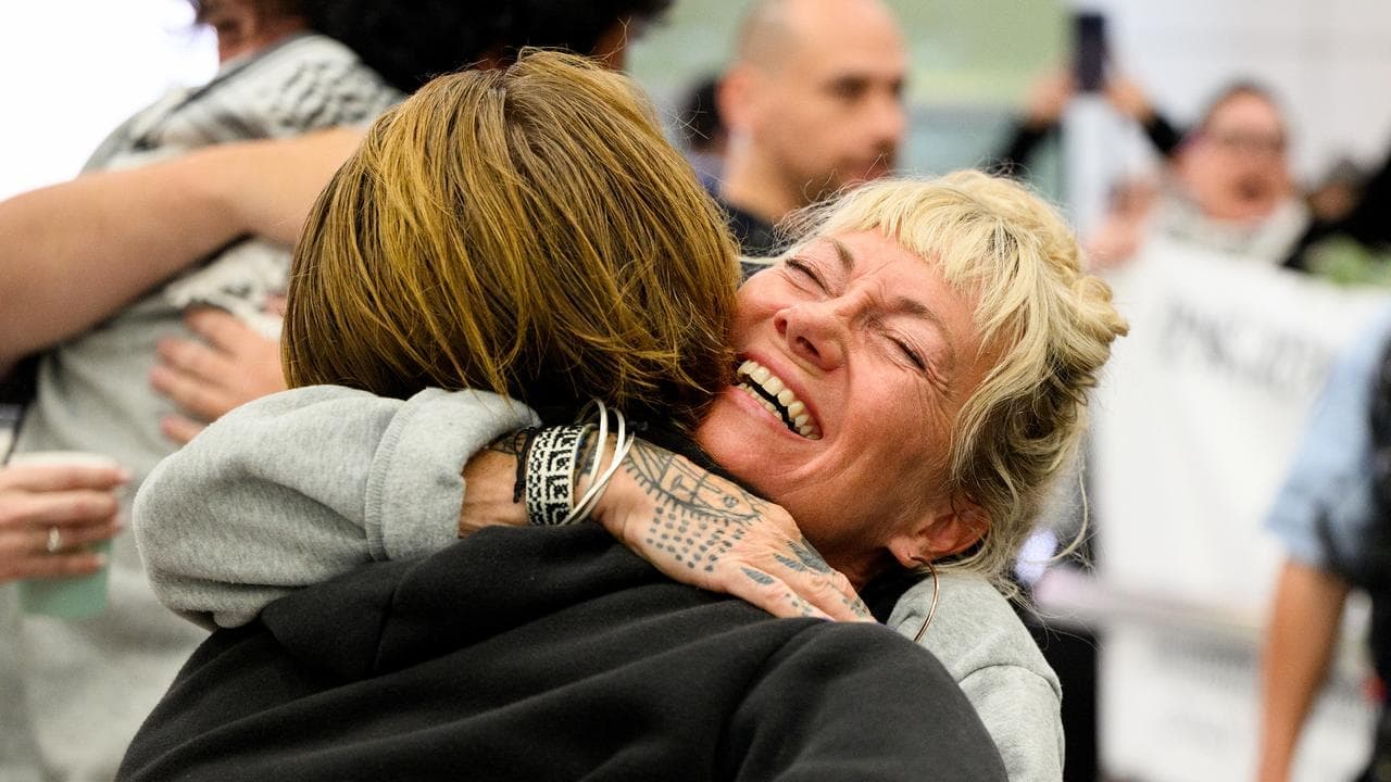 Aussie activists arrive home to applause and chants