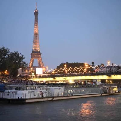 Flame soars, rain falls in historic Paris Games opening