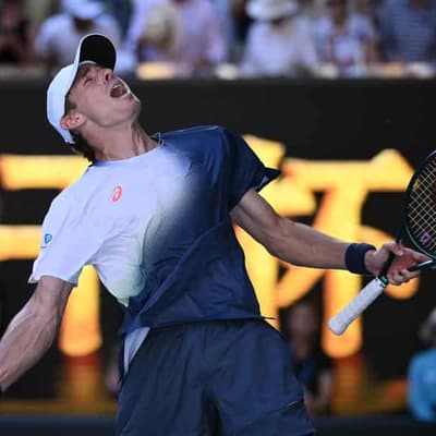 De Minaur survives dogfight to reach Open's second week