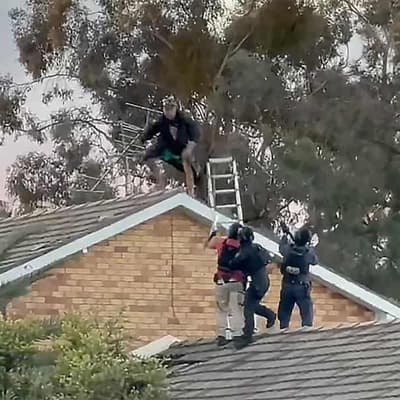 Man charged with murder after rooftop stand-off