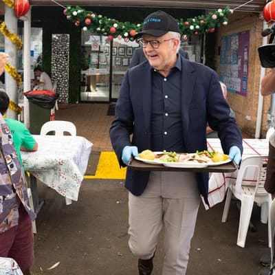 PM picks up the tongs, serving Christmas lunch and hope
