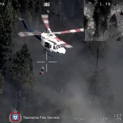 Woman winched to safety in dramatic bushfire rescue